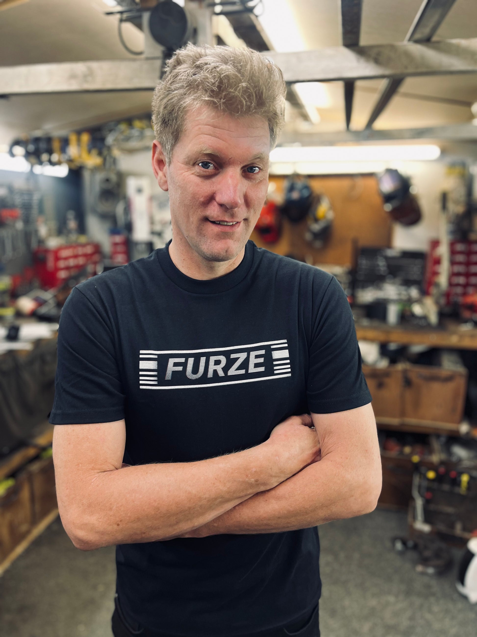 Colin wearing a black 'FURZE' t-shirt in his workshop